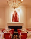 The main dining room is formal in appearance and adorned with shades of Red, and crimson along with wall decorations of blown glass multi colored balloons, and a spectacular sculpture made of red glass rods over the fireplace